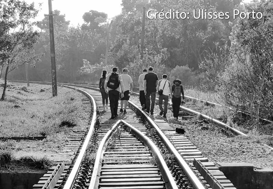 Grupo caminha sob a ponte férrea no bairro da Vila Santana.